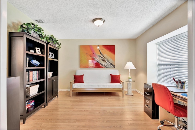 office space featuring a textured ceiling and light hardwood / wood-style flooring