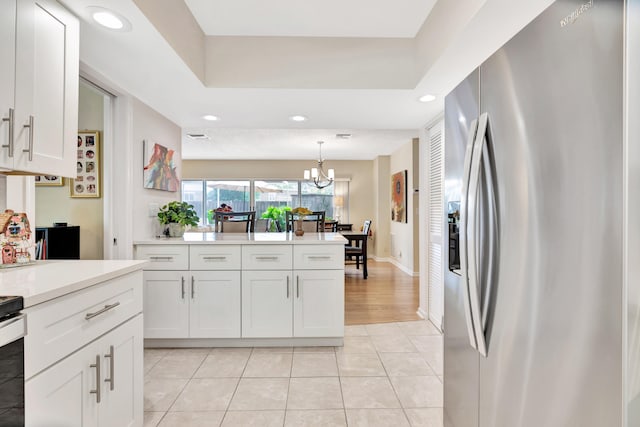 kitchen featuring white cabinets, light tile patterned flooring, decorative light fixtures, and stainless steel fridge with ice dispenser