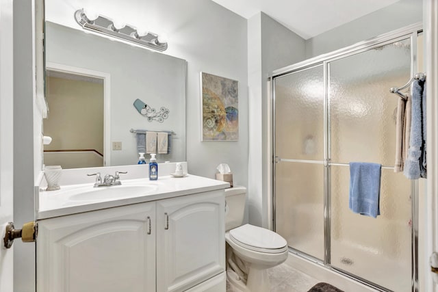 bathroom featuring vanity, toilet, tile patterned floors, and a shower with shower door