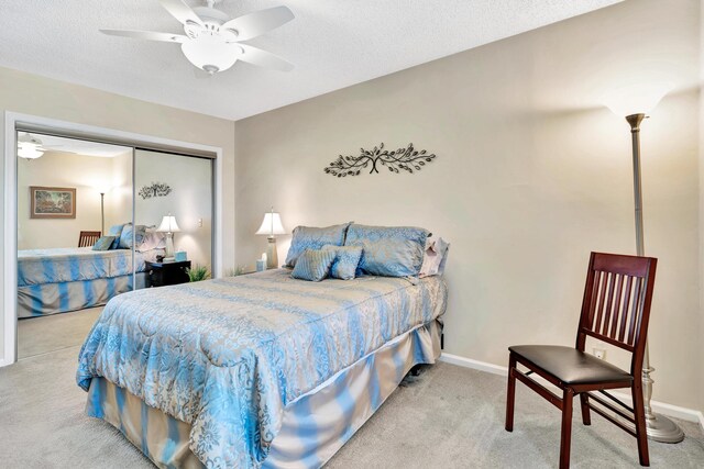 carpeted bedroom with ceiling fan, a textured ceiling, and a closet