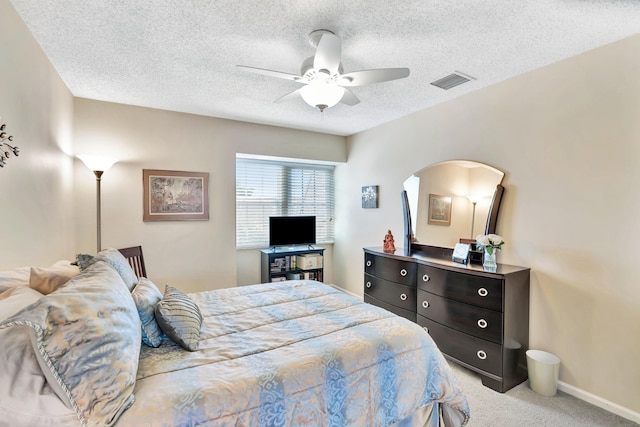 carpeted bedroom featuring a textured ceiling and ceiling fan