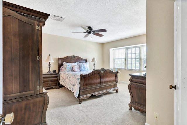 carpeted bedroom featuring a textured ceiling and ceiling fan