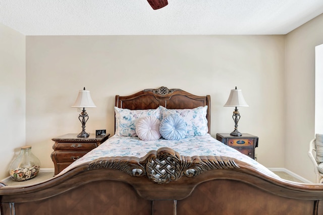 bedroom with ceiling fan and a textured ceiling