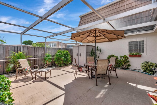 view of patio / terrace featuring a storage unit and a lanai