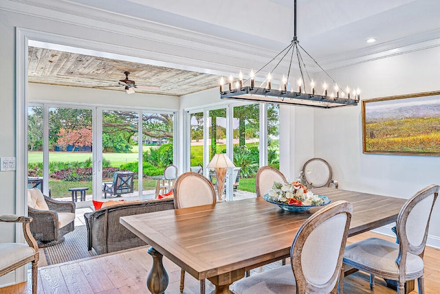 dining room featuring light wood-type flooring, ceiling fan with notable chandelier, wood ceiling, and crown molding