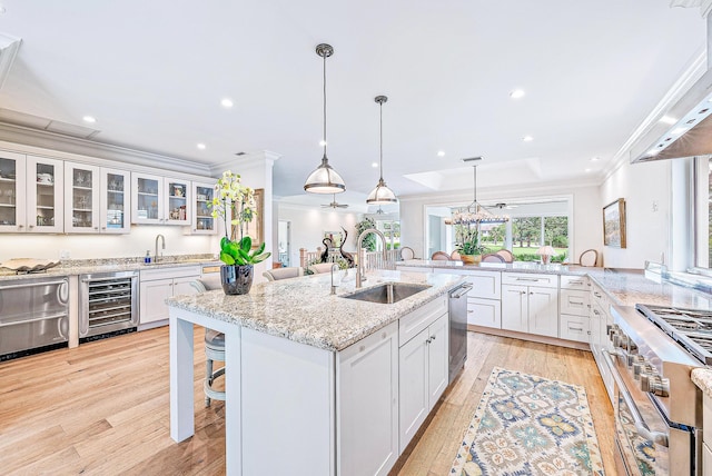 kitchen featuring light hardwood / wood-style floors, sink, beverage cooler, white cabinets, and stainless steel appliances