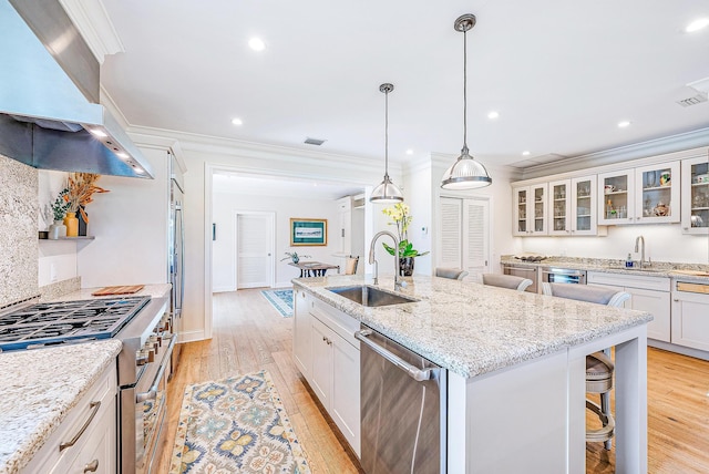 18587 SE Ferland Ct, Jupiter, FL 33469 - kitchen featuring premium range hood, appliances with stainless steel finishes, a sink, an island with sink, and a breakfast bar area