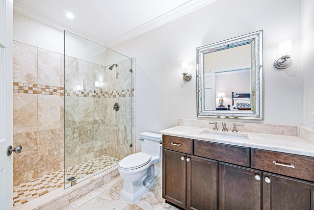 bathroom with a tile shower, vanity, crown molding, and toilet