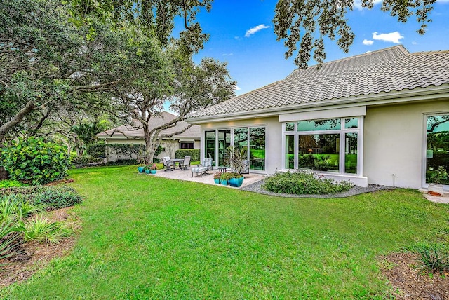 18587 SE Ferland Ct, Jupiter, FL 33469 - back of property with a tile roof, stucco siding, a yard, and a patio area