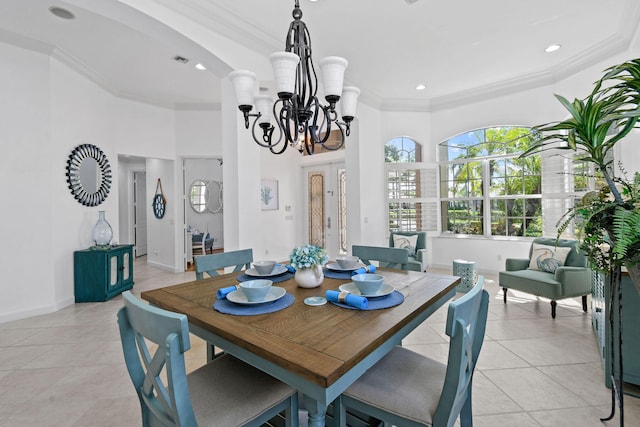 dining area featuring ornamental molding, light tile patterned floors, and an inviting chandelier