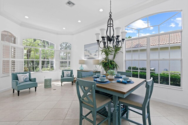 dining space featuring an inviting chandelier, crown molding, and light tile patterned floors