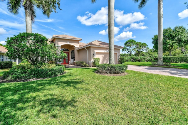 mediterranean / spanish house featuring a garage, a front yard, stucco siding, a tiled roof, and driveway
