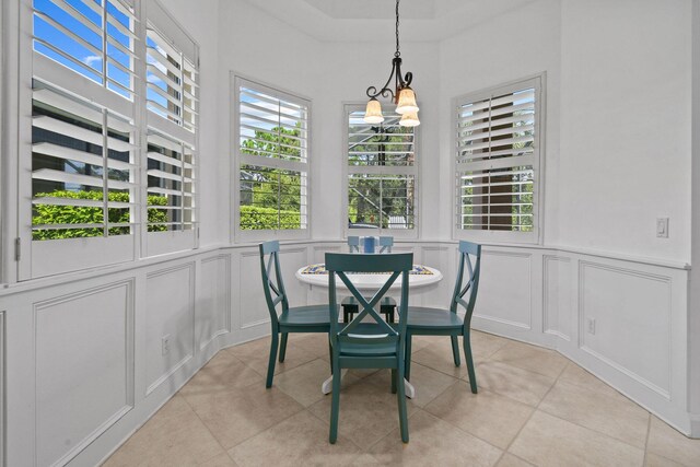 dining space featuring light tile patterned floors, a wealth of natural light, and a decorative wall