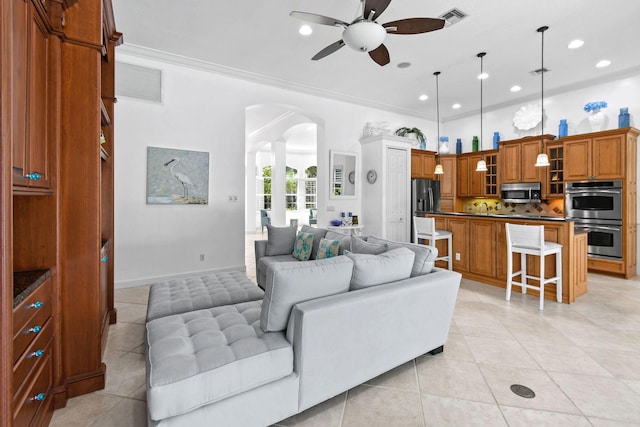 living room with light tile patterned floors, arched walkways, ceiling fan, and recessed lighting