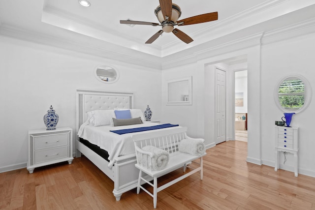 bedroom featuring a raised ceiling, ornamental molding, ceiling fan, and hardwood / wood-style flooring