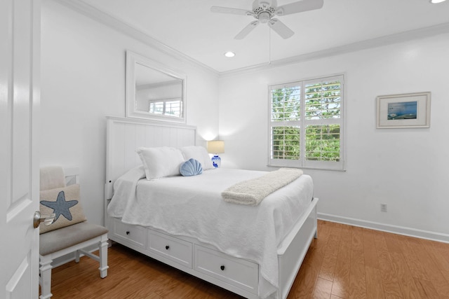 bedroom featuring ceiling fan, hardwood / wood-style flooring, and crown molding