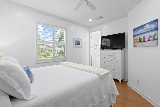 bedroom featuring ceiling fan, hardwood / wood-style flooring, and crown molding