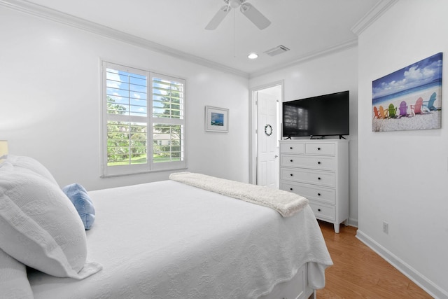 bedroom with ceiling fan, visible vents, crown molding, baseboards, and light wood-style floors