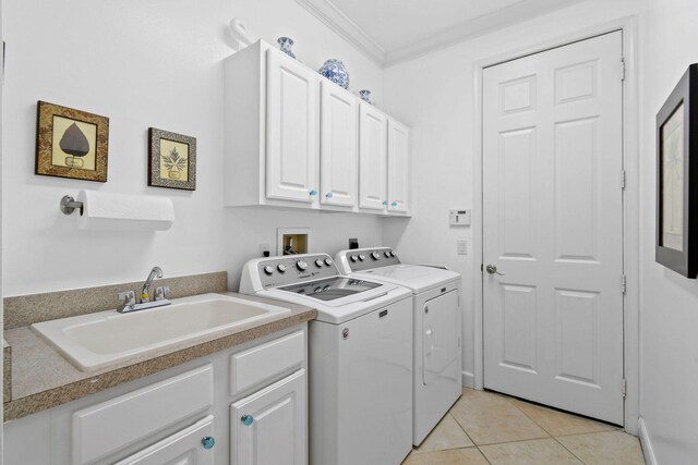 washroom with cabinets, sink, light tile patterned floors, crown molding, and washer and clothes dryer