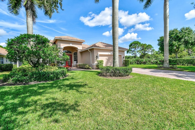 mediterranean / spanish-style house featuring a garage and a front yard