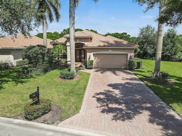 mediterranean / spanish home featuring a front lawn and a garage