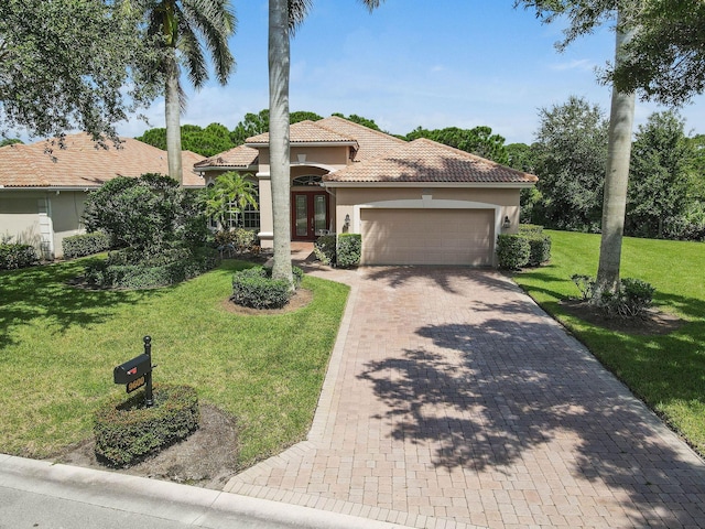 view of front of house featuring an attached garage, a front lawn, stucco siding, french doors, and a tiled roof