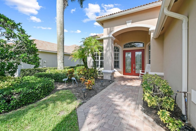 property entrance with stucco siding and french doors