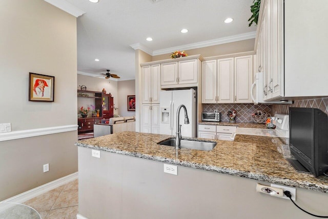 kitchen with ceiling fan, kitchen peninsula, sink, and white appliances