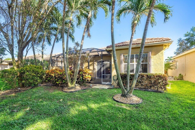 rear view of house featuring a yard and a lanai