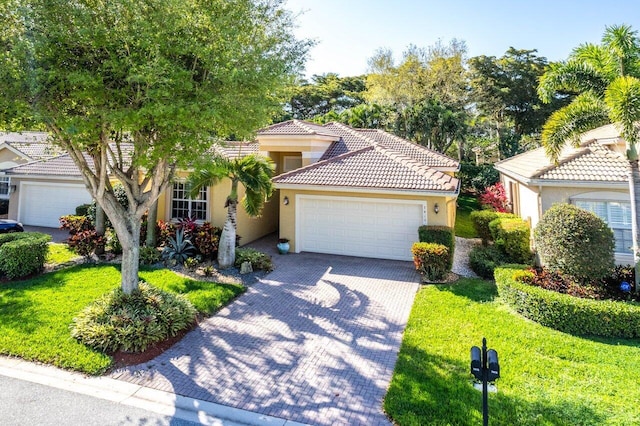 mediterranean / spanish-style home featuring a garage and a front yard