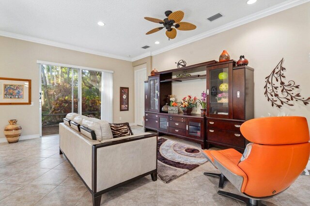 living room featuring ceiling fan, light tile patterned flooring, crown molding, and a textured ceiling