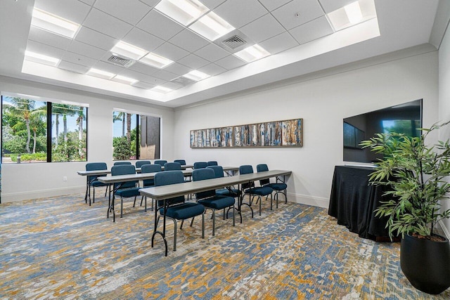 dining area featuring carpet floors and a drop ceiling