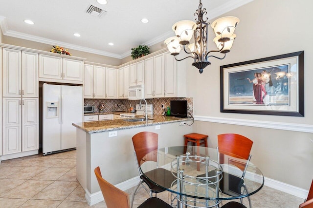 kitchen with kitchen peninsula, pendant lighting, white appliances, light stone countertops, and backsplash