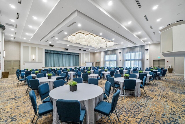 dining area with a towering ceiling, a tray ceiling, and carpet flooring