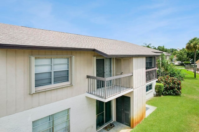 rear view of house featuring a yard and a balcony