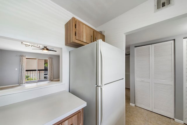 kitchen with ceiling fan, white refrigerator, and light tile patterned flooring