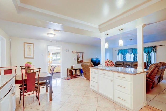 kitchen featuring light tile patterned floors, decorative light fixtures, ornate columns, and white cabinetry