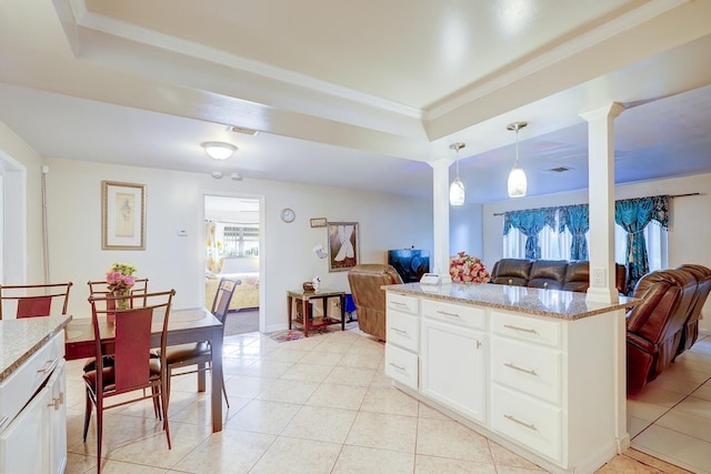 kitchen with crown molding, hanging light fixtures, open floor plan, a raised ceiling, and ornate columns