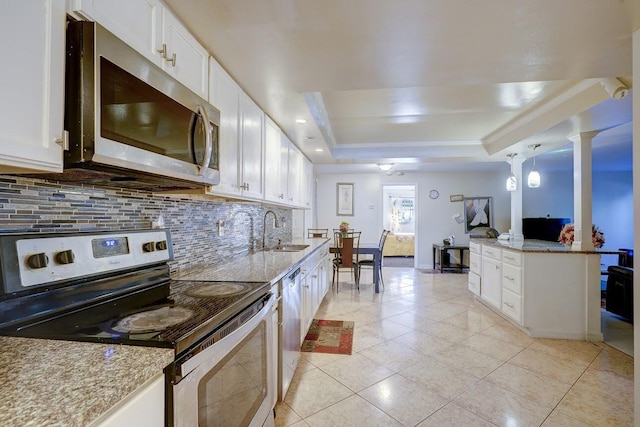 kitchen featuring stainless steel appliances, a sink, light tile patterned flooring, backsplash, and a raised ceiling