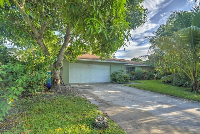 view of front of house with stucco siding, driveway, a front yard, and a garage