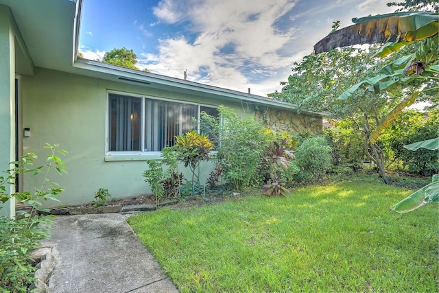 view of property exterior featuring a lawn and stucco siding