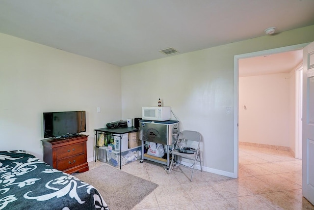 bedroom featuring light tile patterned flooring, visible vents, and baseboards