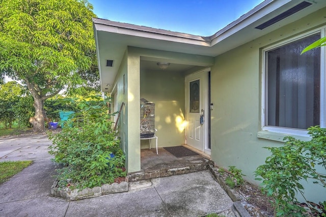 doorway to property featuring stucco siding and a patio area