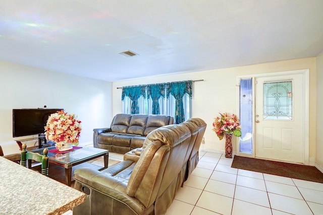 living area featuring baseboards, visible vents, and light tile patterned floors