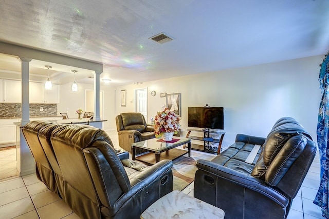 living room featuring decorative columns, visible vents, and light tile patterned floors