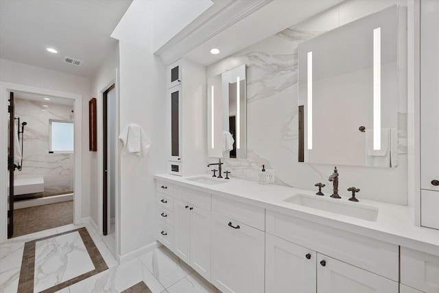 bathroom with tiled shower and vanity