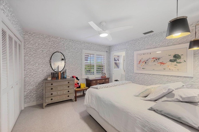 bedroom with ceiling fan, a closet, and light colored carpet