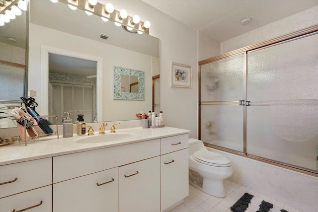 full bathroom with combined bath / shower with glass door, vanity, tile patterned floors, and toilet