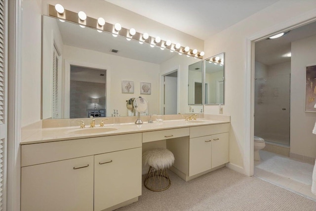 bathroom featuring vanity, toilet, and a shower with door