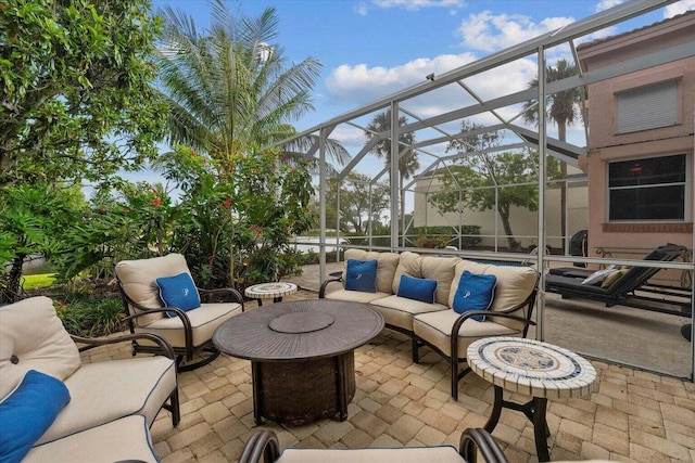 view of patio / terrace featuring an outdoor living space with a fire pit and a lanai